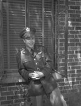 Young man in military uniform standing by window by W. D. Smith