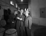 Three men looking at a piece of paper by W. D. Smith