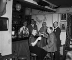 A woman and six men gathered around a bar by W. D. Smith