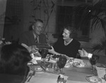 Man and woman sitting at dining table by W. D. Smith