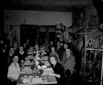 Group sitting at dining table by W. D. Smith