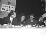 Group gathered around table with Ad Club sign in background by W. D. Smith