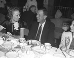 People sitting at a dining table by W. D. Smith