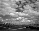 Cloudy sky with a farm house in distance by W. D. Smith