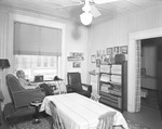 A man with a cigar sitting on a lounge chair by an apartment window by W. D. Smith