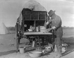 Cook preparing a meal at chuck wagon