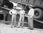 Men standing beside truck on lift by W. D. Smith