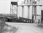 Men standing beside truck on lift by W. D. Smith