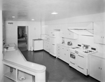 A very large kitchen with all white cabinets and appliances by W. D. Smith