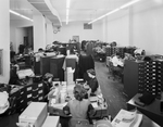 An office crowded with workers and filing cabinets by W. D. Smith