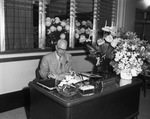 J. Lee Johnson Jr. sitting at his desk, taking the office of presidency (organization unknown) by W. D. Smith