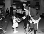 Christmas party, Santa Claus handing gift to a young girl by W. D. Smith