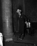 Man standing in front of a microphone by W. D. Smith