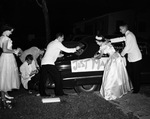 Wedding entourage preparing the bride and groom get-away car by W. D. Smith