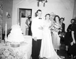 The bride with her parents by the wedding cake by W. D. Smith