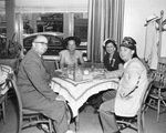 Group eating while seated by a window by W. D. Smith