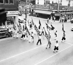 The United States and Texas flags lead the start of an All State Shrine parade by W. D. Smith