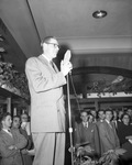 A man on stage and speaking at a Christmas party by W. D. Smith