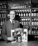 Mr. Pruett in front of Calvert liquor display by W. D. Smith