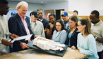 Professor Observing Building Model by University Photographer