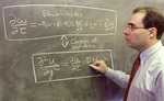 Professor Writing on Chalkboard by University Photographer