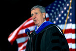 Speaker in front of flag by University Photographer