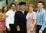 Student posing for photos at graduation ceremony by University Photographer